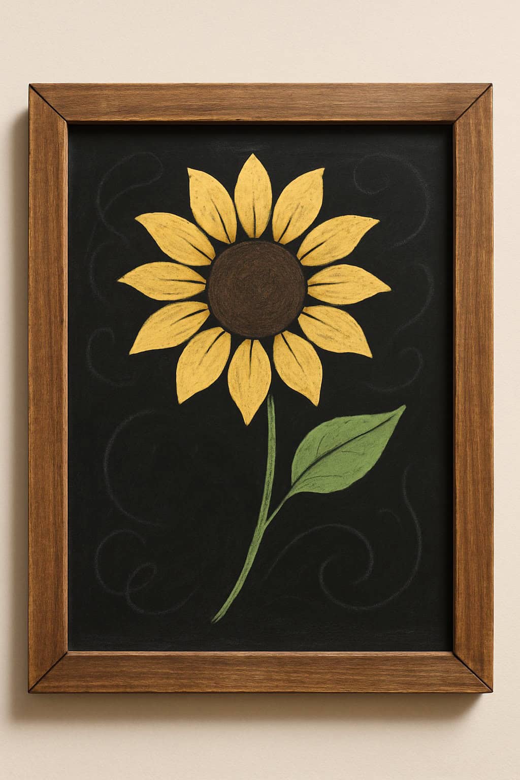 Framed chalkboard art depicting a bright yellow sunflower with a brown center and a green leaf, set against a black background with faint decorative swirls.