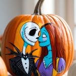 A pumpkin painted with Jack Skellington and Sally from "The Nightmare Before Christmas," shown facing each other affectionately. The artwork is colorful and detailed, set in a bright indoor setting.