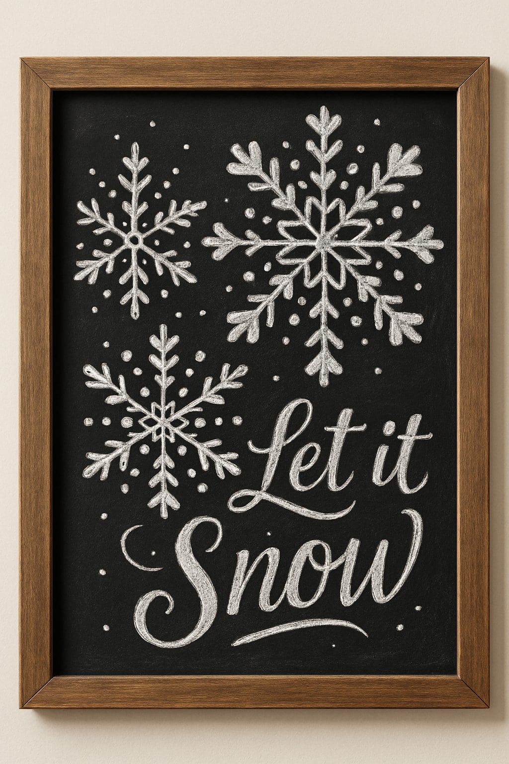 A wood-framed chalkboard displaying detailed snowflake designs made of heart and dot shapes on a clean background.