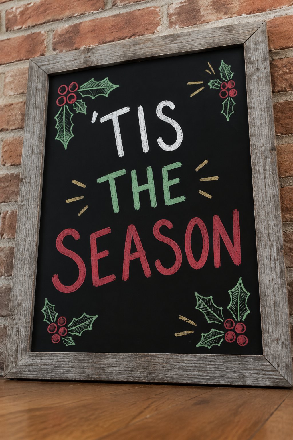 Tis the Season: a hand-drawn christmas chalkboard sign drawn without words, holly leaves with berries around the words.
