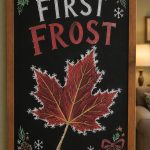 A hand-drawn christmas chalkboard sign reading "FIRST FROST".